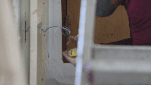 Person measuring wall for wiring installation