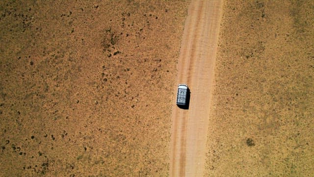 Vehicle Traveling Along a Desert Road