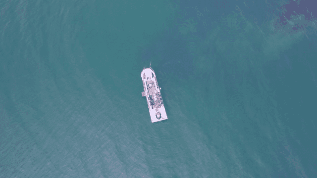 맑은 푸른 물 위를 항해하는 배