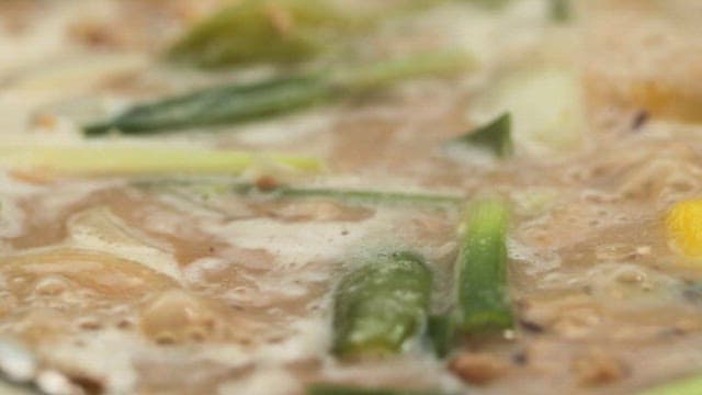 끓고 있는 다양한 채소와 두부가 푸짐히 들어간 청국장 한 숟가락