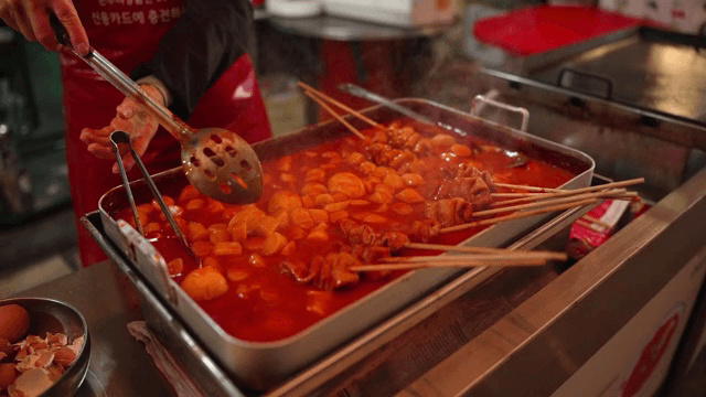 길거리에서 매운 떡볶이를 준비하는 상인