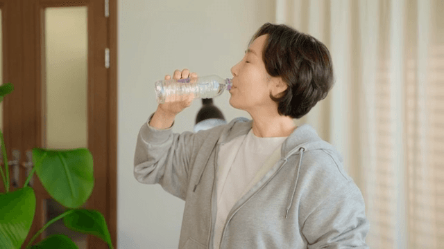 Woman checking time while drinking water