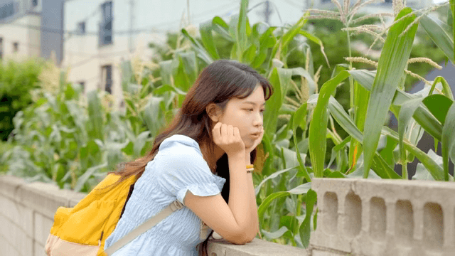 옥수수 식물을 관찰하는 젊은 여성