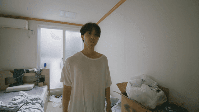 어수선한 방에서 망치를 든 젊은 남성