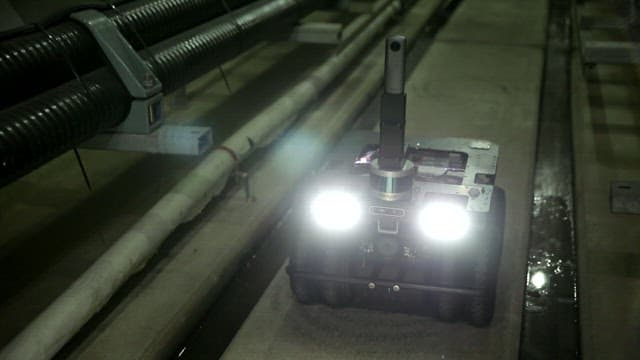 희미한 불빛의 산업 환경에서 파이프를 검사하는 로봇