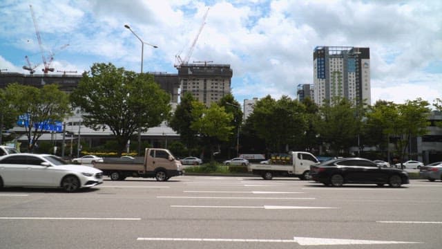 도시의 공사 현장 옆 도로를 지나가는 자동차