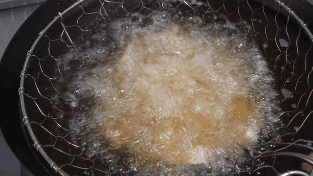 Tofu being deep-fried in hot oil