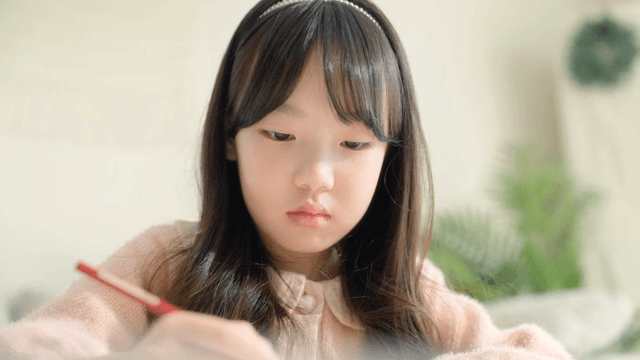 Young girl focused on drawing indoors