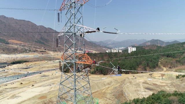 Workers inspecting transmission towers in mountainous areas