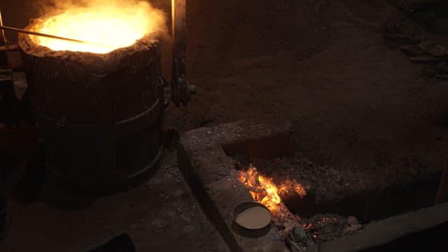 Worker handling molten metal in a foundry