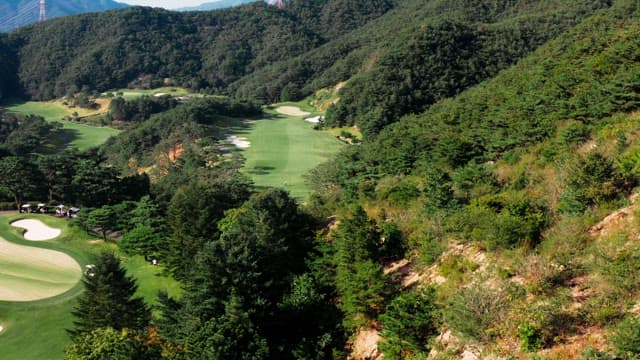 Golf course nestled in verdant mountain valley