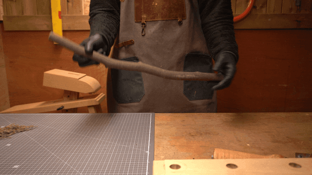 작업실에서 나무 막대를 들고 있는 사람