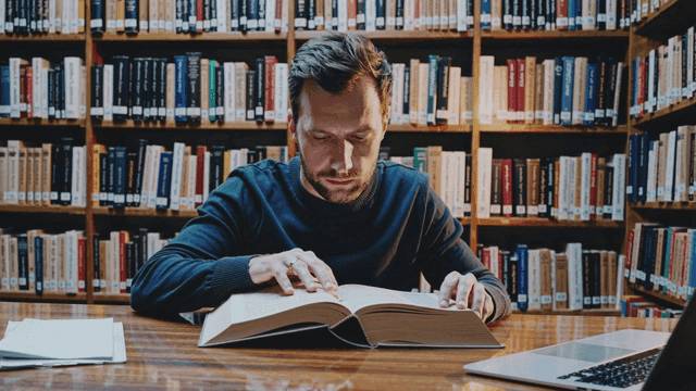 도서관에서 집중하며 공부하는 백인 남성