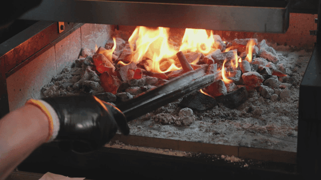 집게로 숯을 정리하는 사람