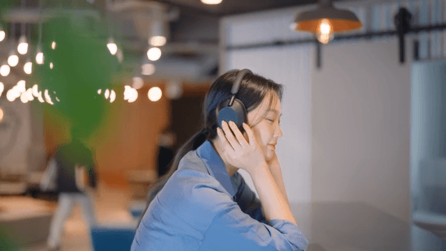 실내에서 헤드폰으로 음악을 즐기는 여성