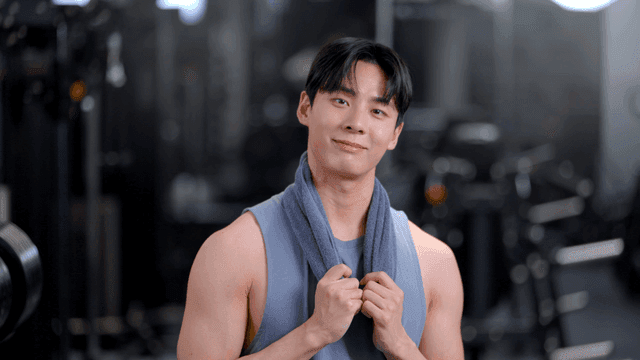 헬스장에서 수건을 목에 두르고 정면을 보는 젊은 남자