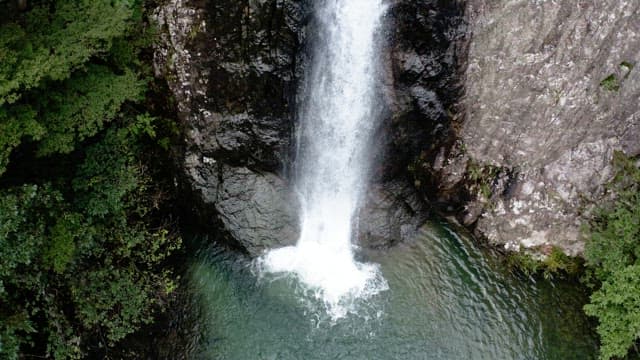 Majestic waterfall cascading between lush green cliffs