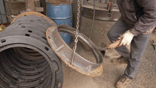 Worker handling metal parts in a factory