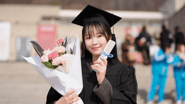 Graduate holding a diploma and flowers