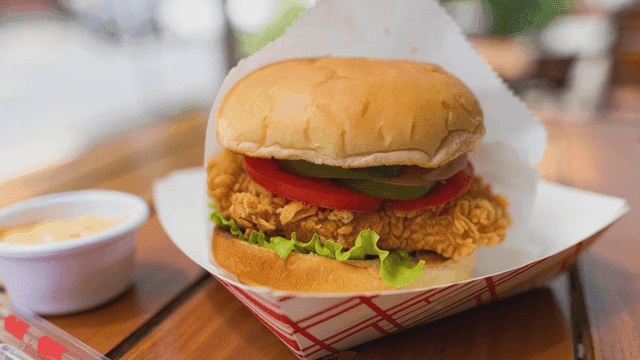 나무 테이블 위의 바삭한 치킨 버거