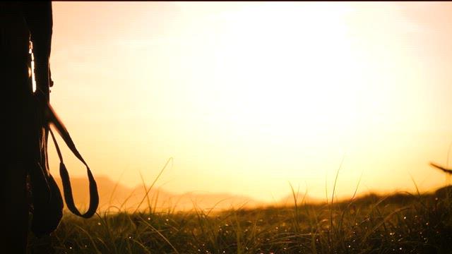 Silhouette of a person with camera at sunset