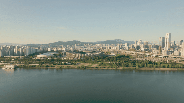 A city skyline with a river and stadium