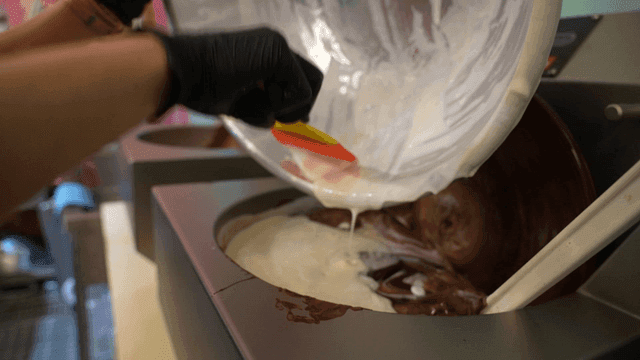 Pouring fresh cream into a chocolate mixer