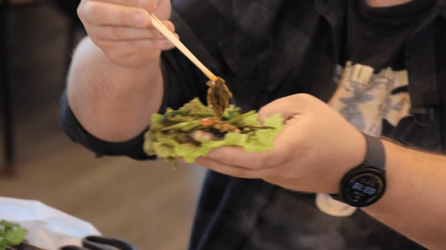 Preparing lettuce wraps with Grilled Pork Belly and water parsley