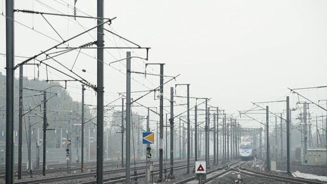 High-speed train approaches on a foggy railway track