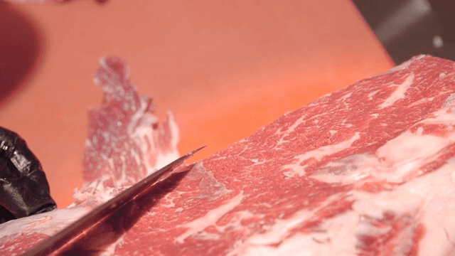 Slicing raw beef with a sharp knife