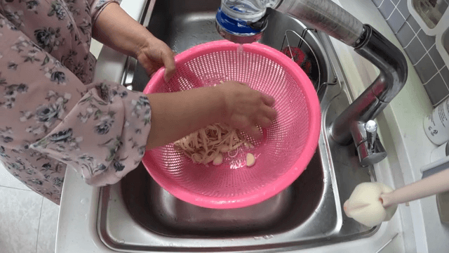 싱크대에서 마늘과 면을 씻는 모습