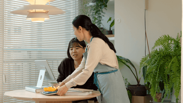 Mother bringing fruit and daughter looking at tablet