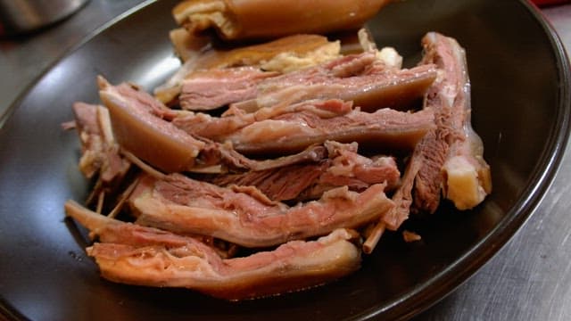 검은 접시에 가지런히 플레이팅된 맛있는 수육 요리