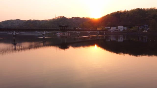 Scenic bridge over a calm river at sunset