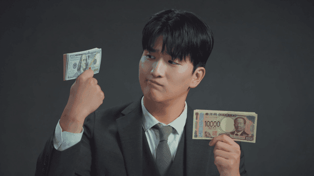 Man smiling at the Japanese yen in his hand