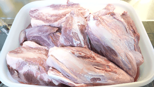 Raw meat pieces in a white container