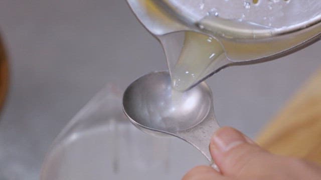 Pouring lemon juice into a measuring spoon