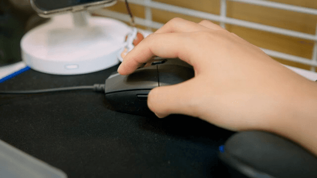 Hand using a computer mouse on a desk