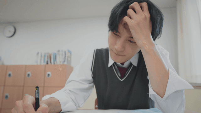 Student checking the time nervously while taking an exam