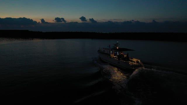 Boat cruising at twilight on calm waters