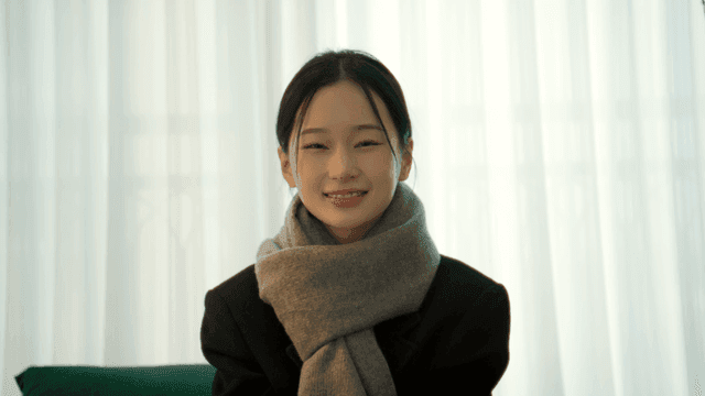 Woman smiling while looking straight ahead in cozy living room