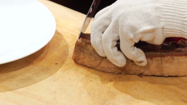 Slicing juicy cooked boiled pork on a board