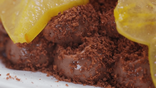 노란 과일 조각이 올려진 초콜릿 디저트