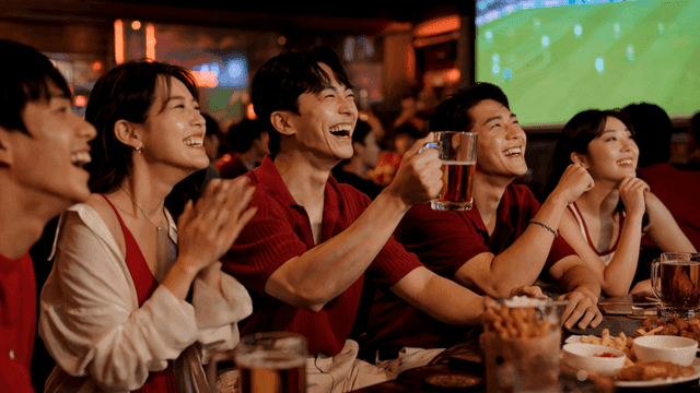Friends enjoying beer while watching soccer match