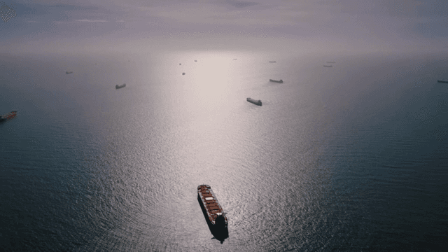 흐린 하늘 아래 고요한 바다의 화물선