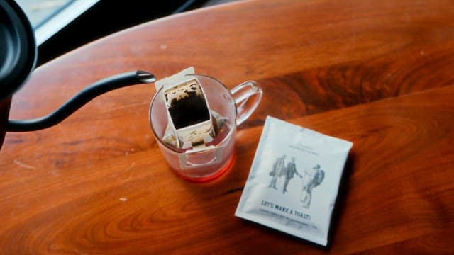 나무테이블 위에 준비된 티백 위로 따뜻한 물 붓기