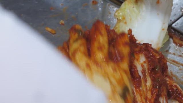 배추에 고추 양념을 넣어 김치를 만드는 모습