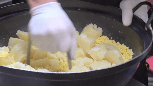 Mixing potatoes and eggs in a large pot