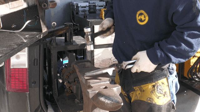 Farrier who makes horseshoes with hammer
