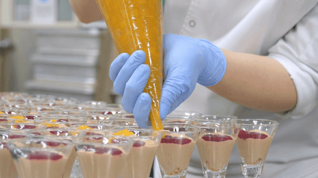 Chef decorating dessert with fruit toppings